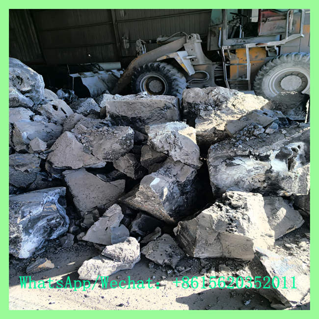 Industrial calcium carbide lumps piled in factory with wheel loader