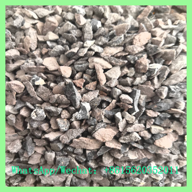 Close-up view of grey calcium carbide lumps and granules for industrial application