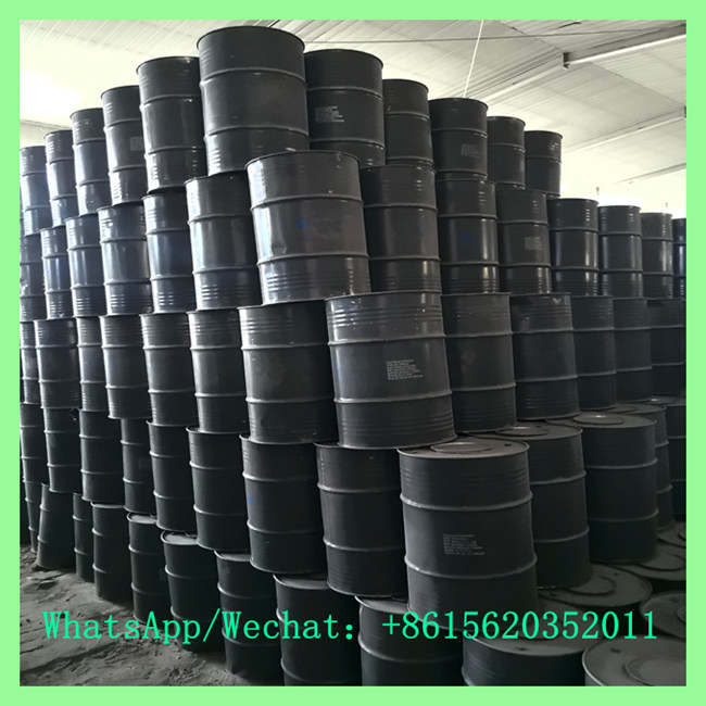 High stack of sealed black steel drums containing 15-25mm calcium carbide inside a chemical supply warehouse. Contact +8615620352011