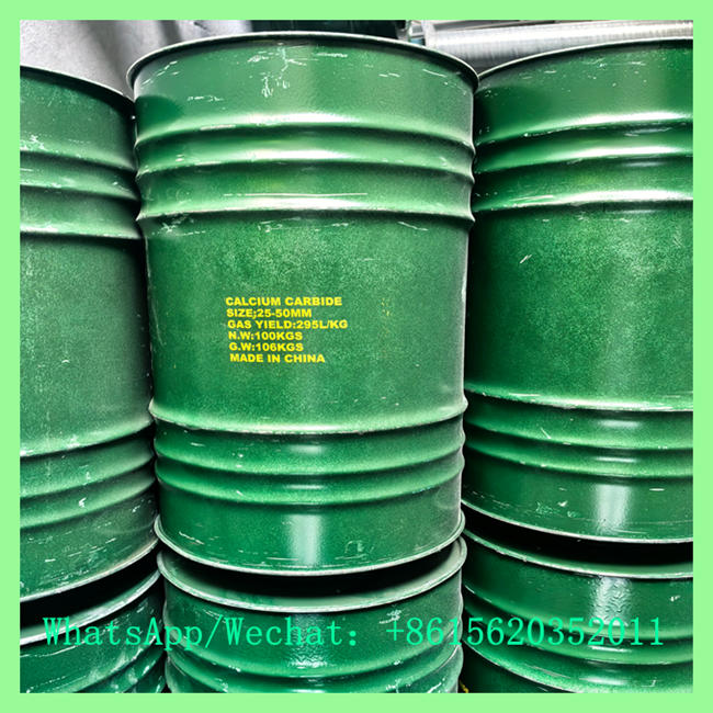 Close-up view of green metal chemical drums with yellow text stenciled on the surface reading