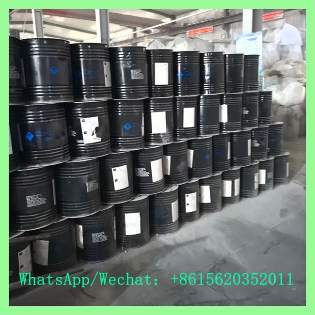 Stacked black steel drums containing high-purity calcium carbide crystals inside an industrial warehouse