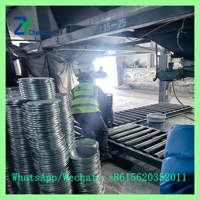 Factory worker processing and packaging calcium carbide 50-80mm lumps into sealed steel drums